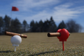 Red and white BogeyforStogies cigar stands holding cigars above the golf course grass
